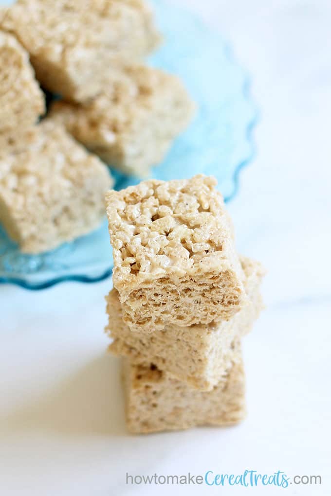 brown butter Rice krispie treats stacked with title brown butter Rice krispie treats stacked with title brown butter Rice krispie treats stacked with title brown butter Rice krispie treats with blue glass plate in background