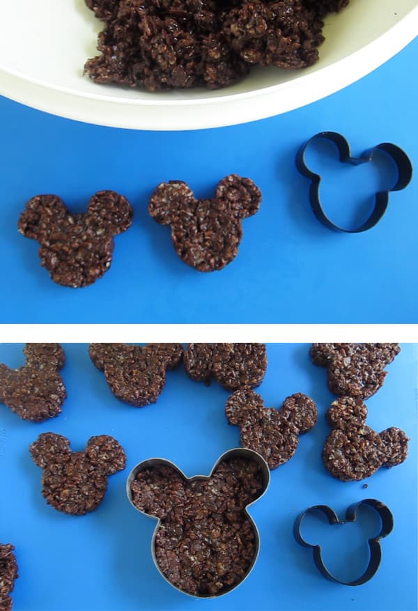 filling Mickey Mouse shaped cookie cutters with chocolate rice krispie treat mixture