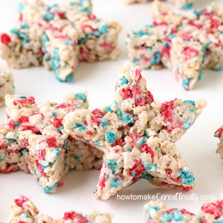red, white and blue star shaped rice krispie treats piled up on a white table