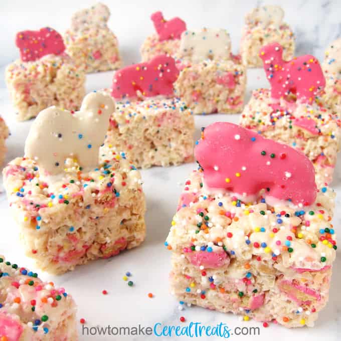 Pink and white Circus Animal Cookies top rice crispy treats loaded with more cookies and rainbow sprinkles.