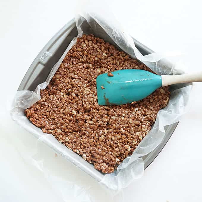 pressing chocolate layer in baking pan for ice cream sandwich Rice Krispie treats