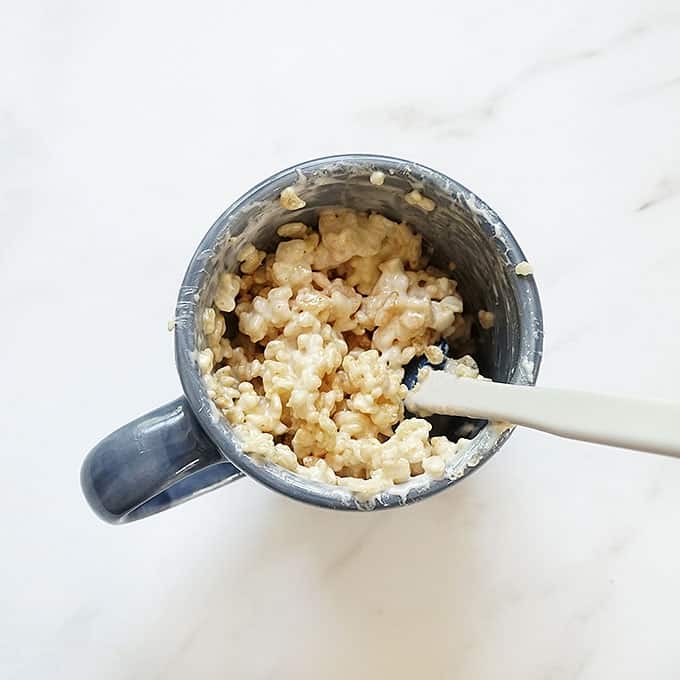 stirring rice krispie treat in a mug