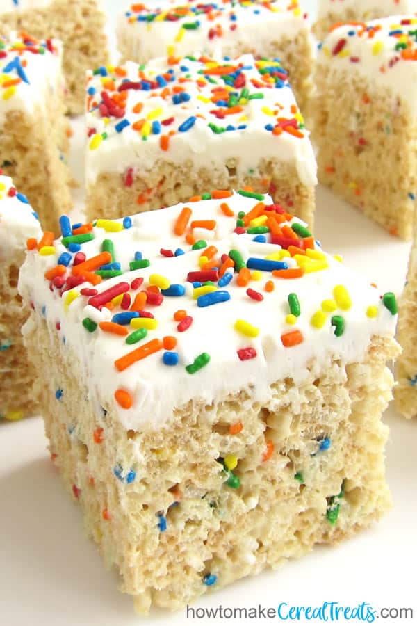thick birthday cake-flavored rice krispie treats are topped with a layer of vanilla frosting and lots of rainbow sprinkles