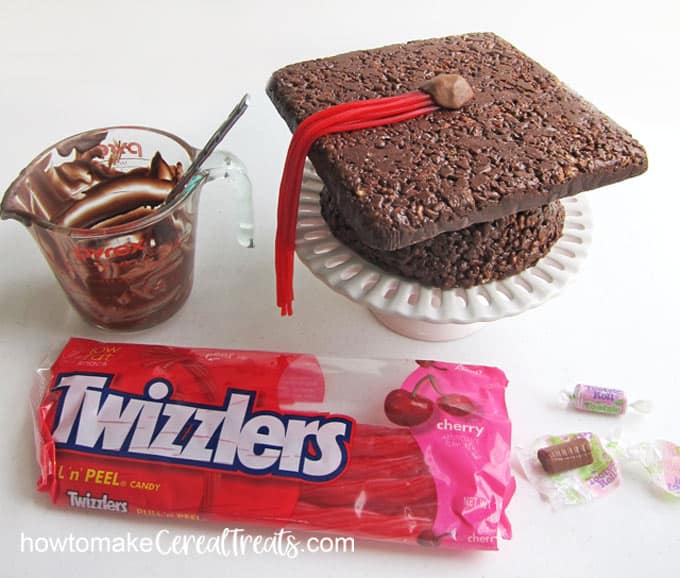 Attach Twizzlers Pull 'n Peel licorice laces to the chocolate Rice Krispies treat graduation cap.