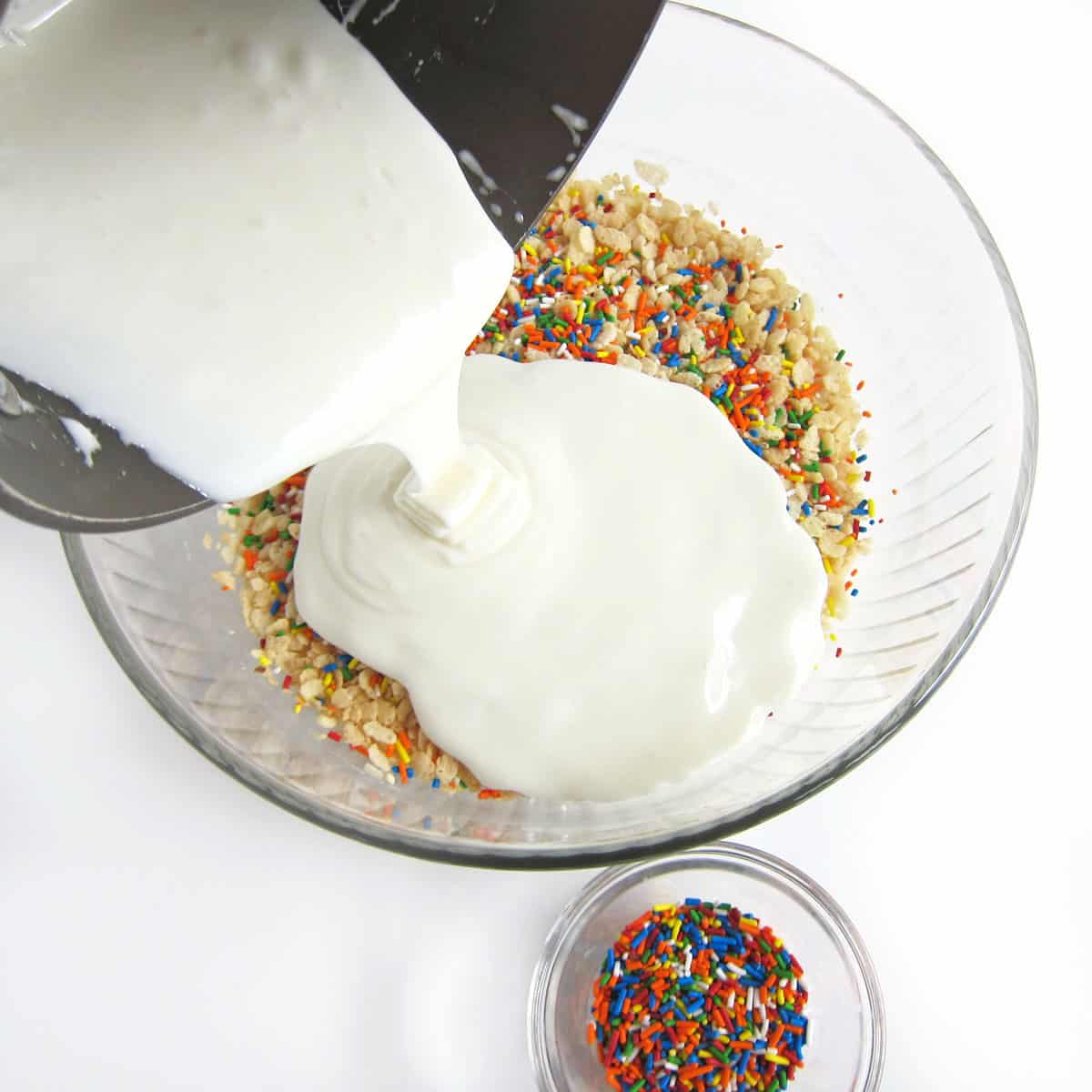 pouring melted butter and marshmallows over Rice Krispies cereal and rainbow sprinkles