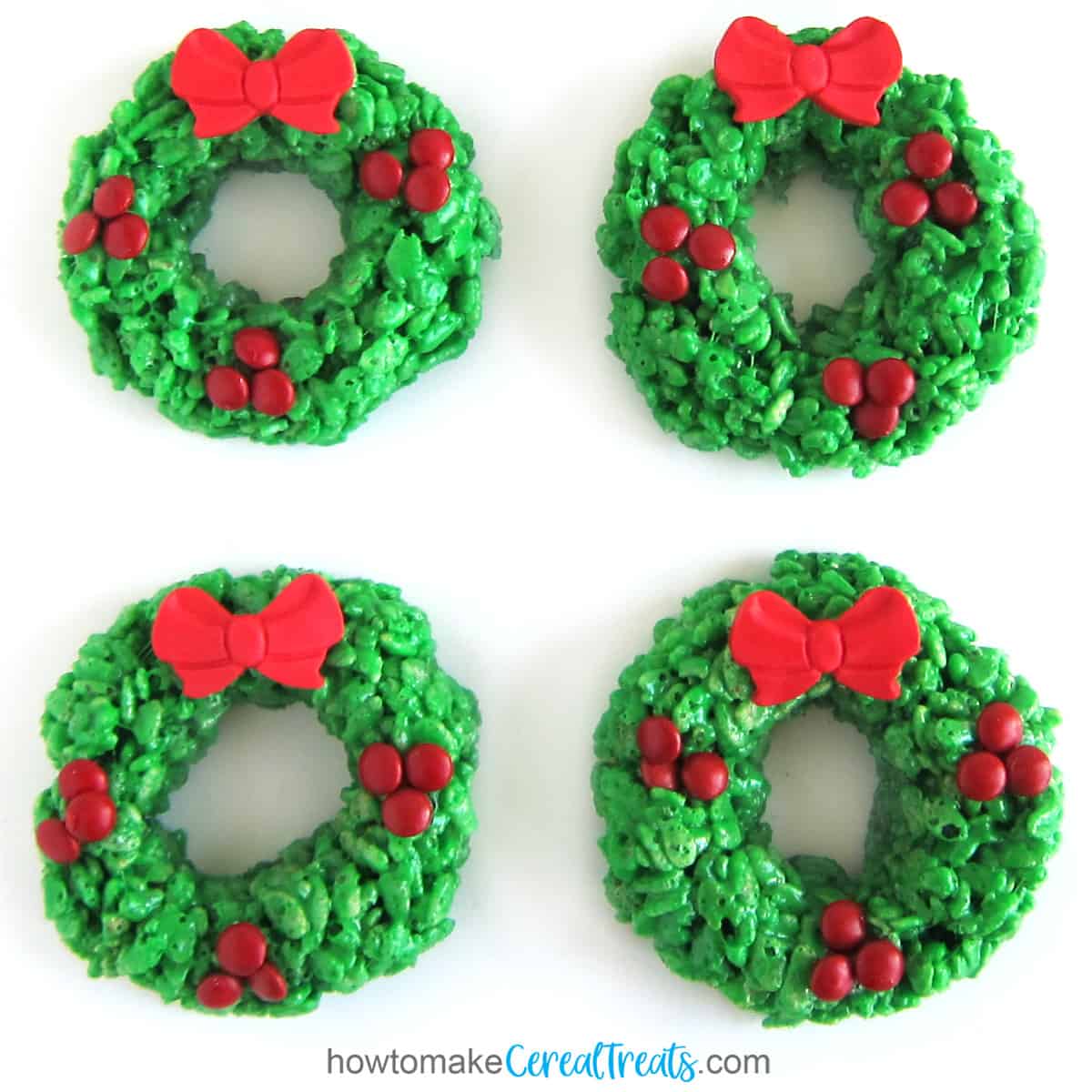 Christmas Rice Krispie Treat Wreaths topped with mini red M&M's and a red modeling chocolate bow.