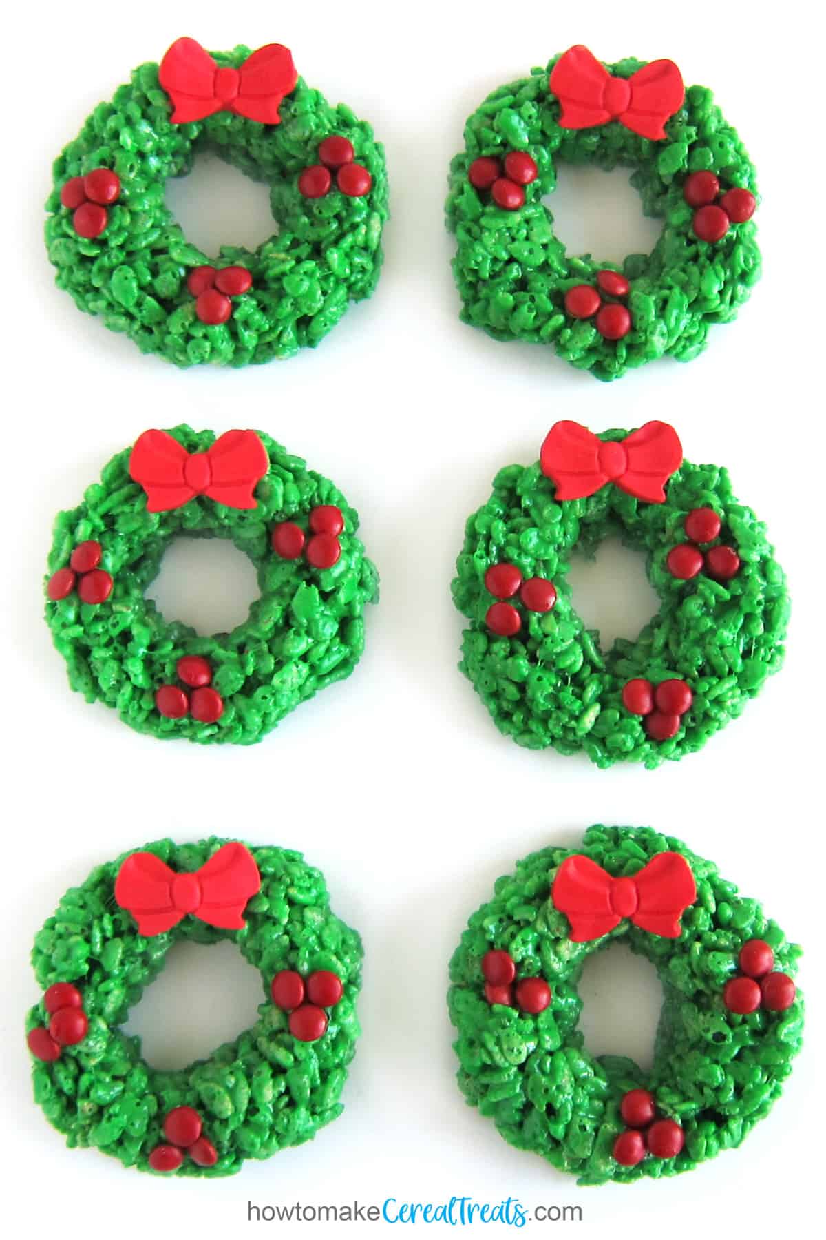 green Rice Krispie treat wreaths with mini M&M berries and a red modeling chocolate bow