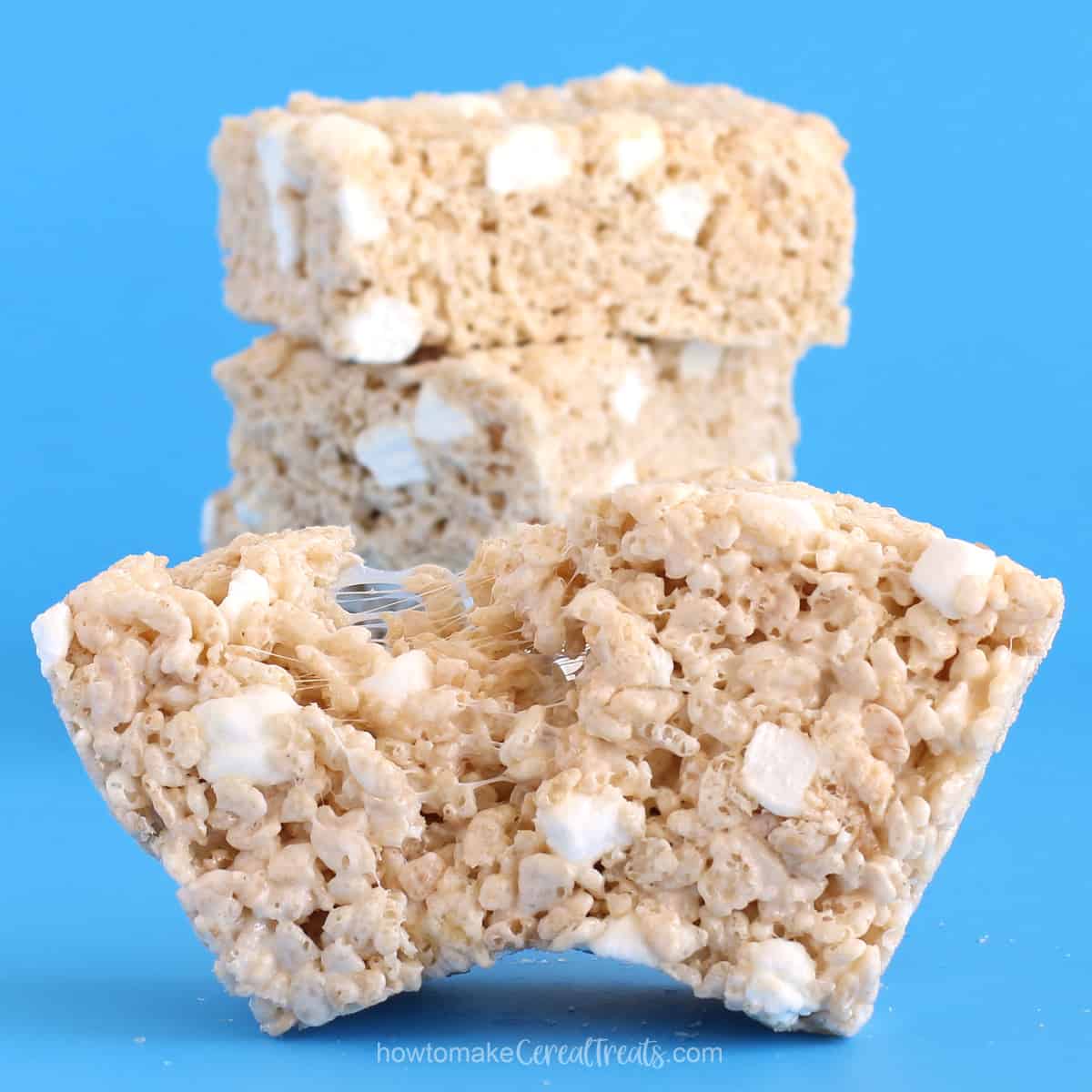 Gooey homestyle rice crispy treats pulled apart showing the gooey marshmallows.