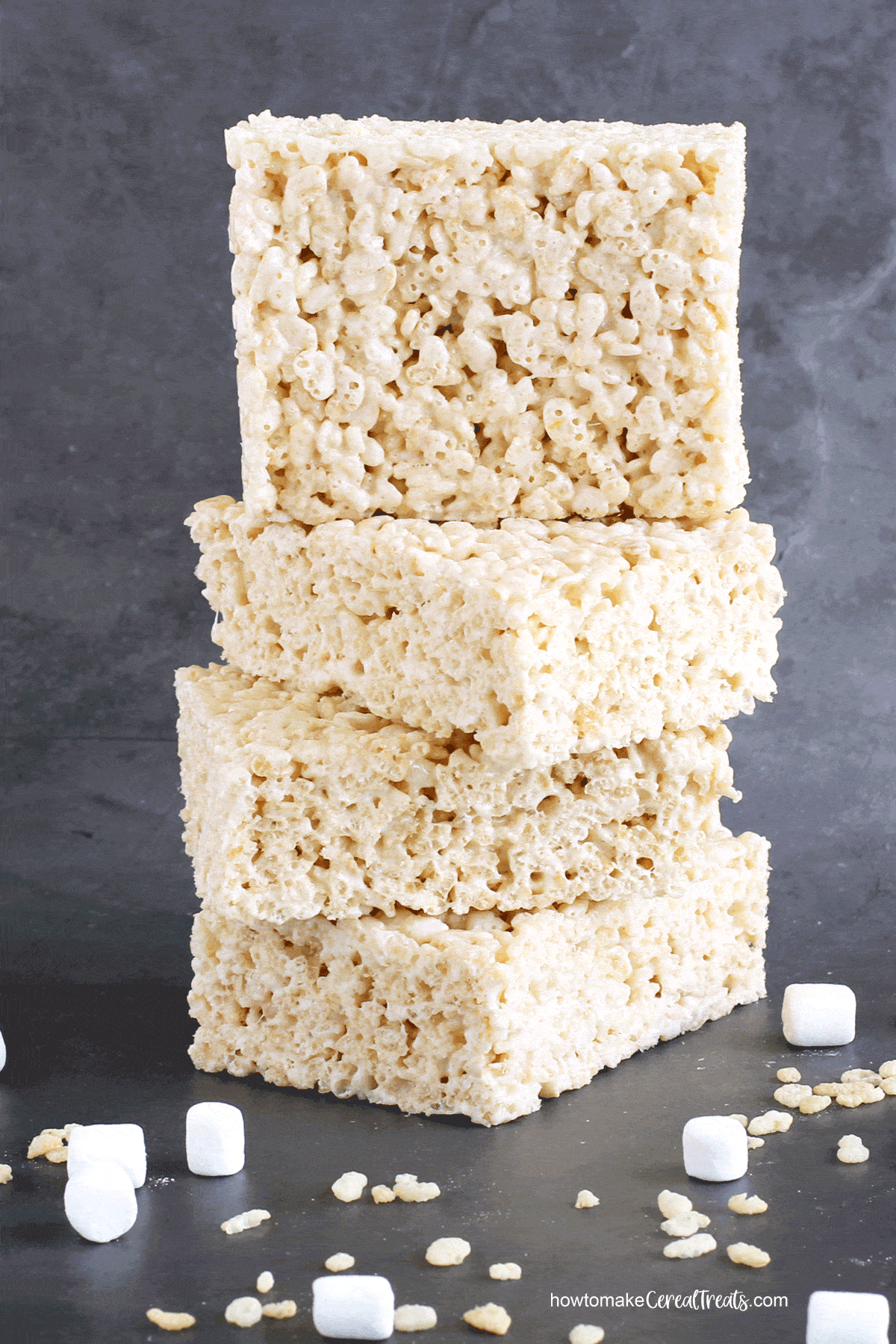big Rice Krispie Treats stacked next to Rice Krispies Cereal and mini marshmallows