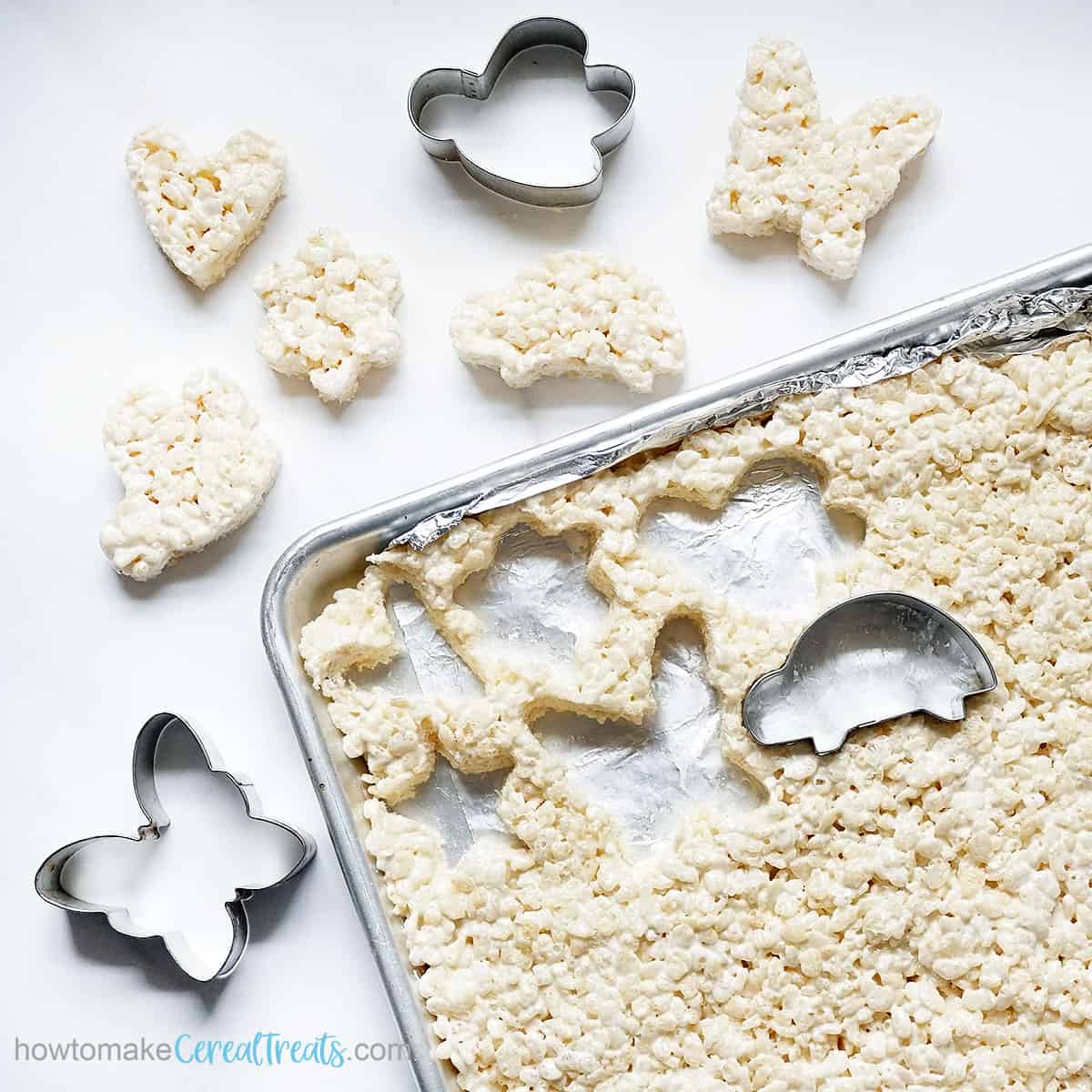 Cutting out Rice Krispie Treat shapes with cookie cutters. 