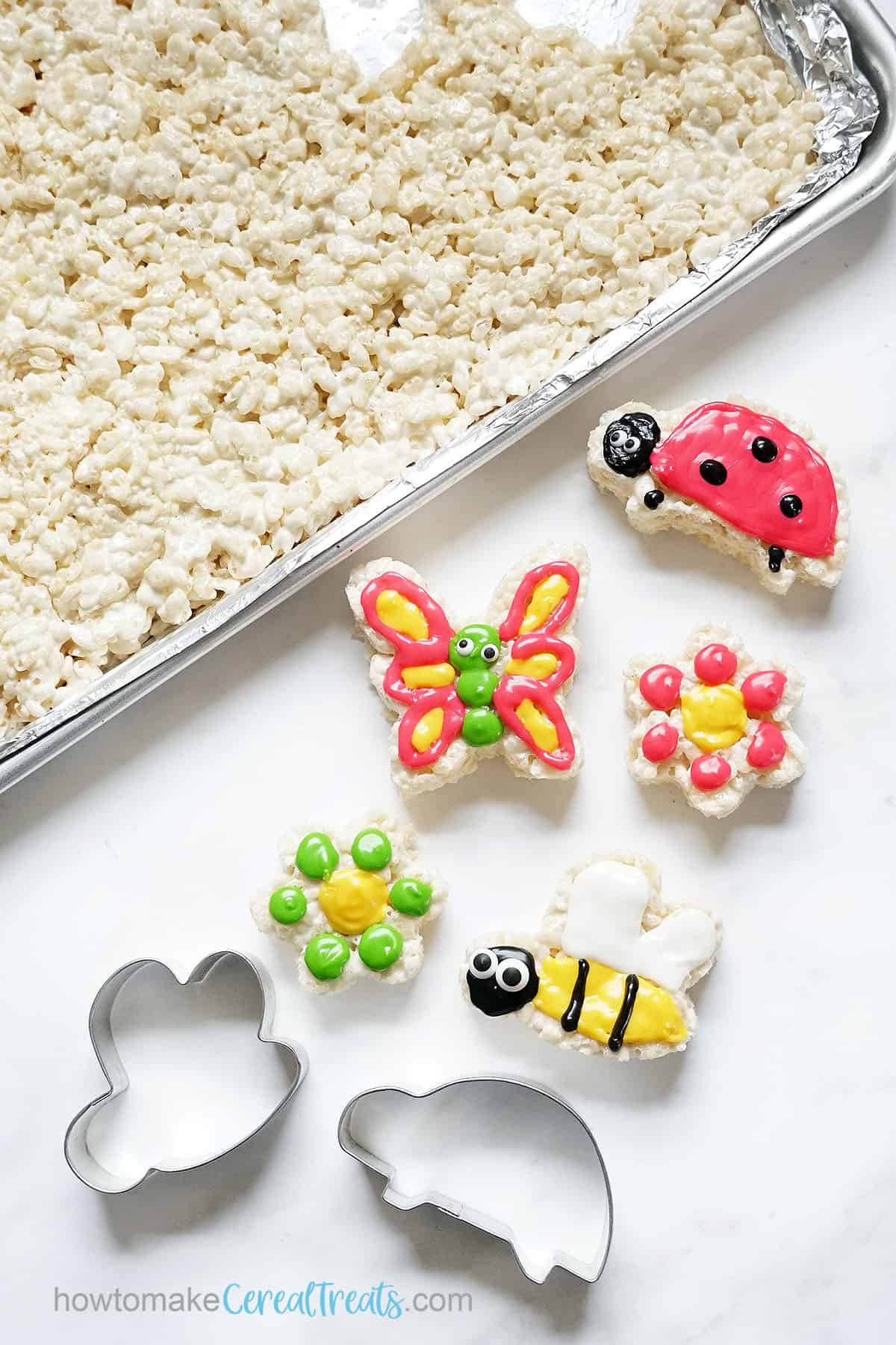 Sheet pan rice krispie treats with cut-out treats decorated with icing 