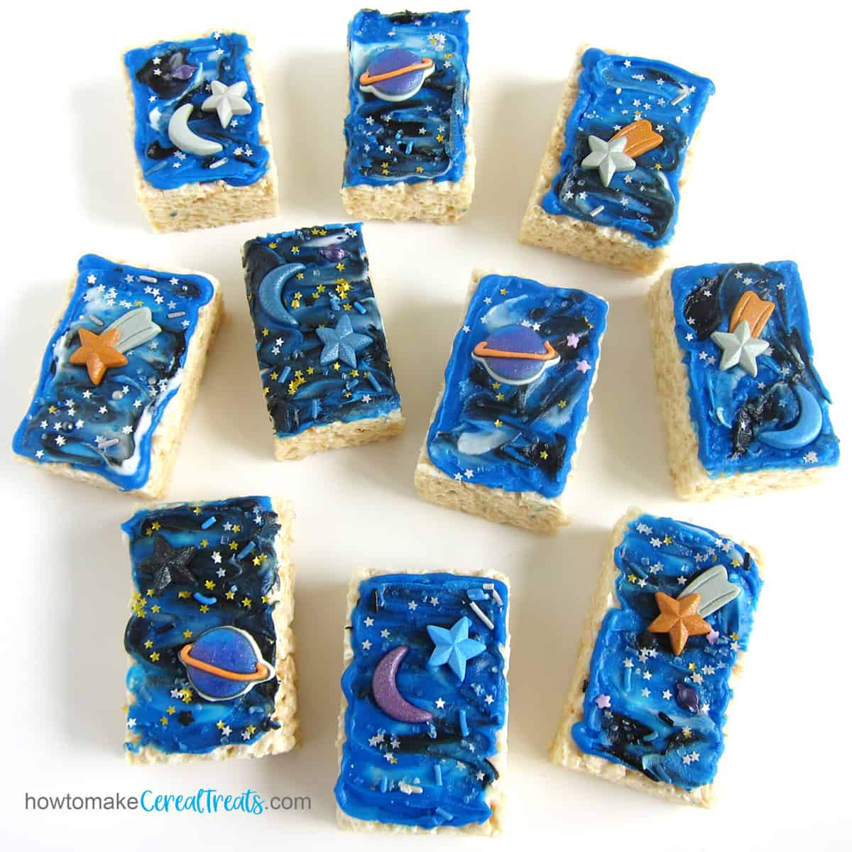 Frosted galaxy rice krispie treats decorated with stars, moons, and planets.