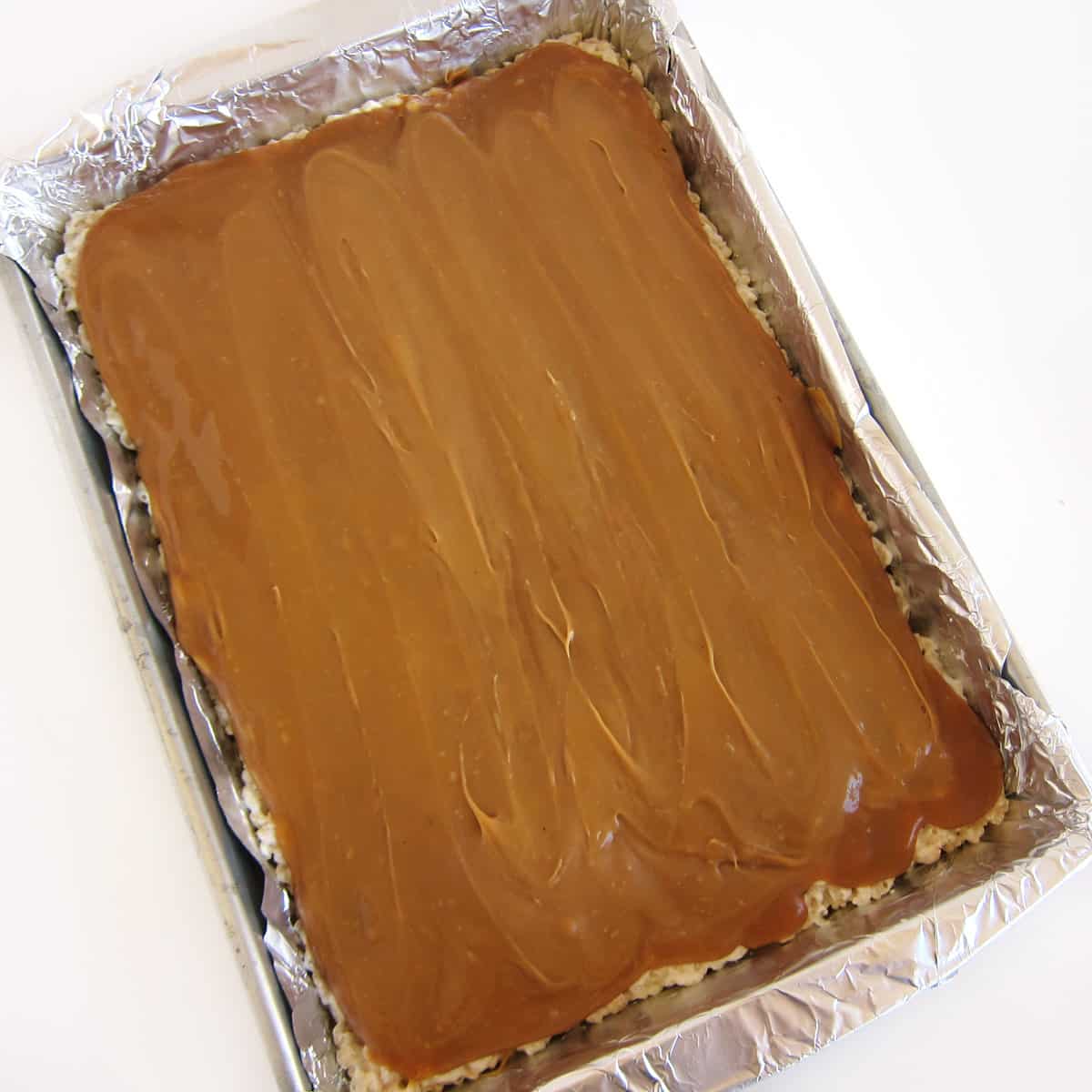 caramel spread in a layer over rice krispie treats
