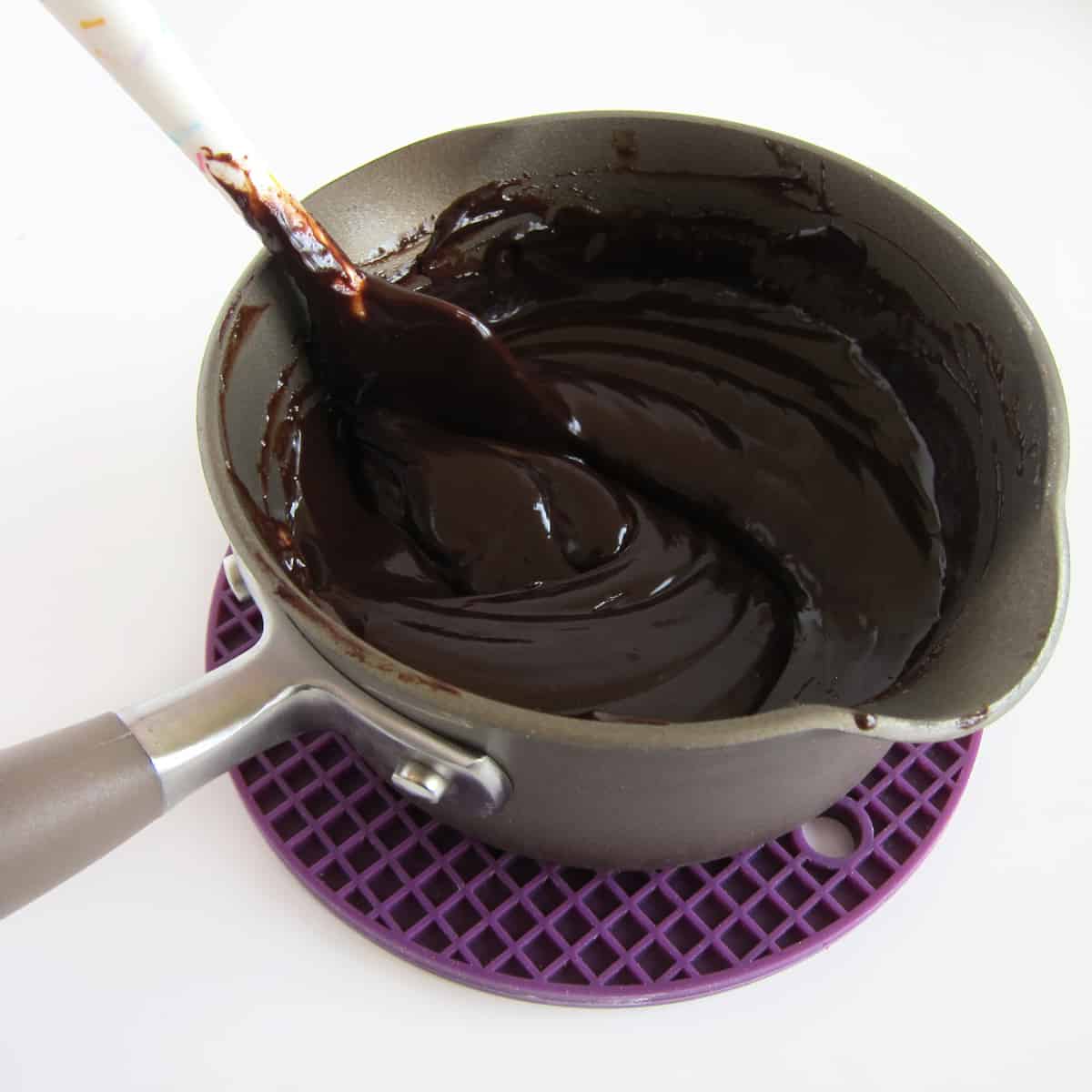 stirring chocolate ganache in saucepan
