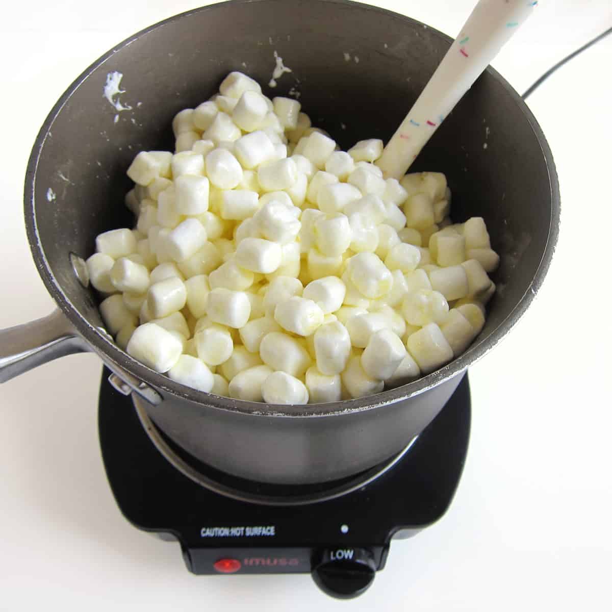 mix marshmallows into melted butter in saucepan