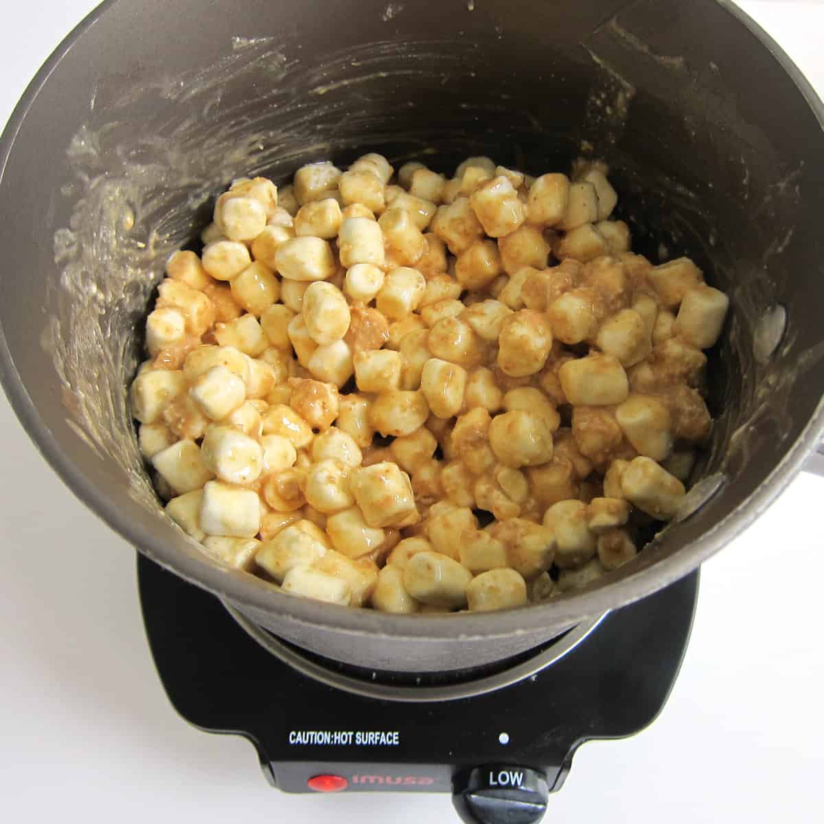 saucepan filled with mini marshmallows coated in cashew butter and melted butter