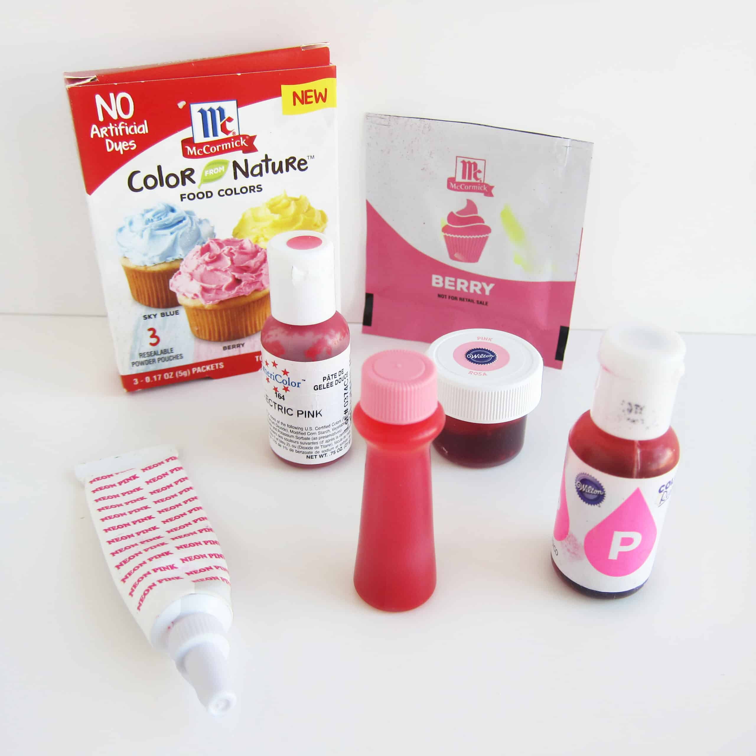 variety of pink food coloring bottles, jars, and pouches