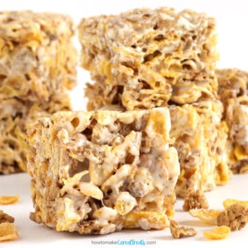 marshmallow Honey Bunches of Oats Bars with cereal sprinkled on the table next to the treats