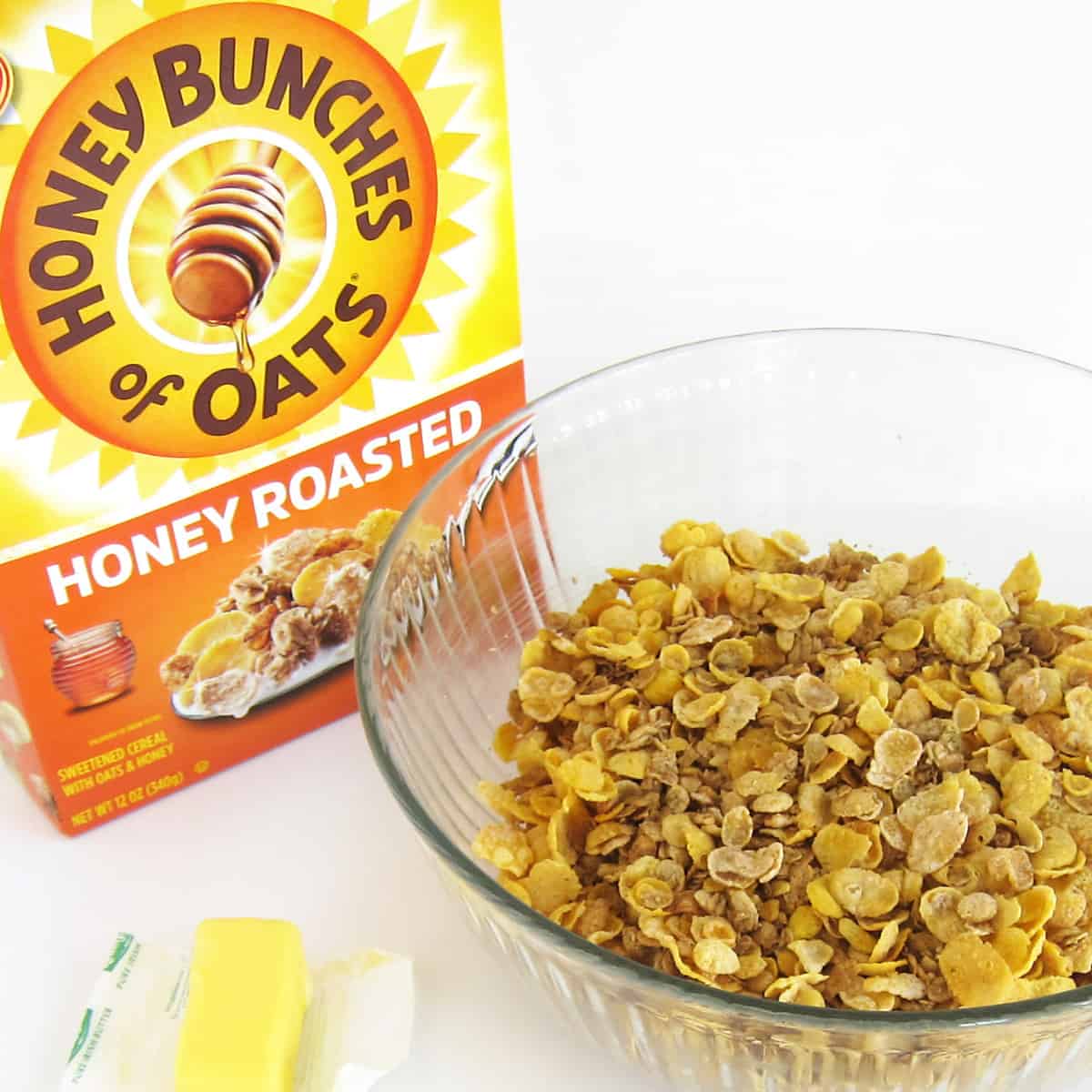 Honey Bunches of Oats cereal in a mixing bowl that has been greased with butter