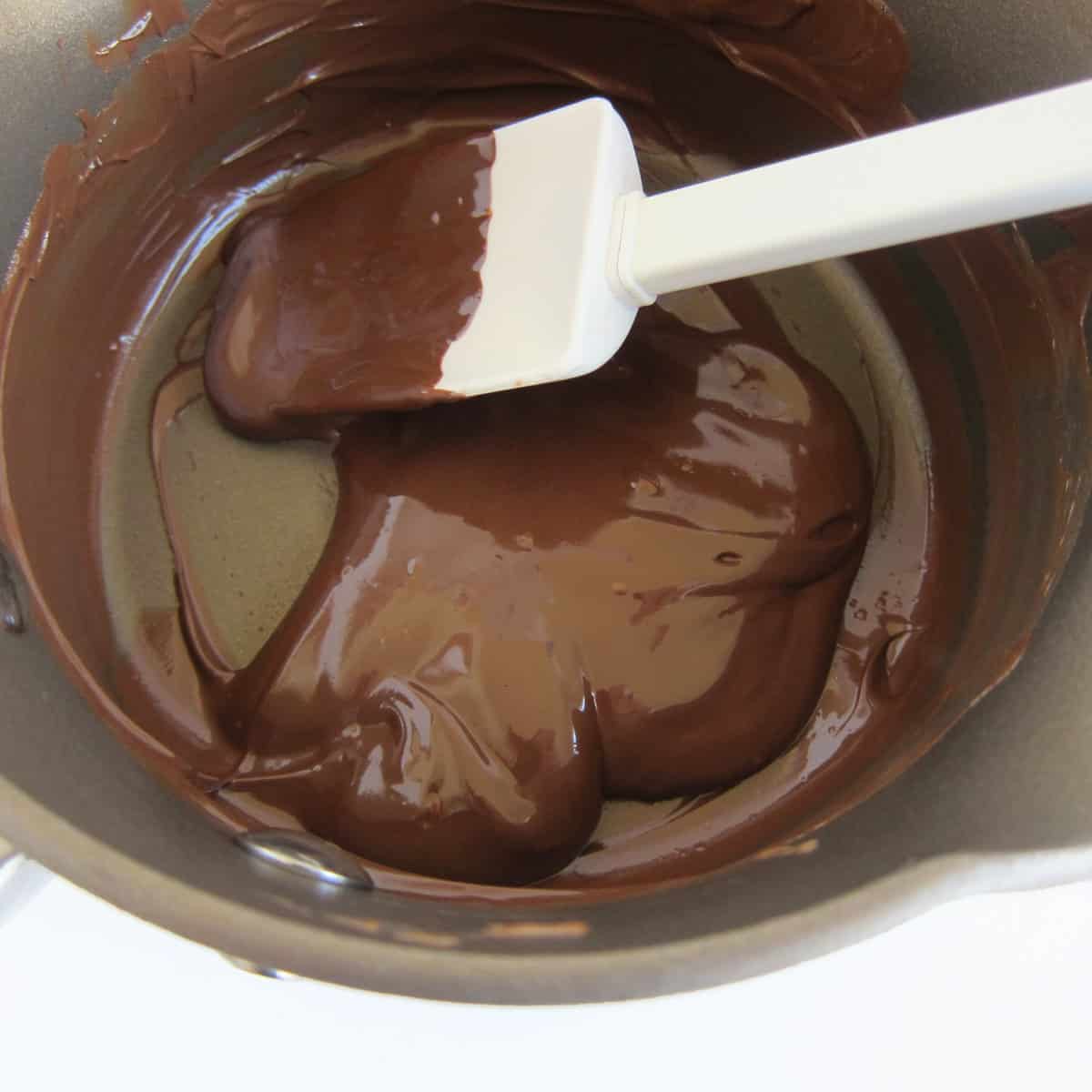 melted chocolate and Nutella in a saucepan with a silicone spatula