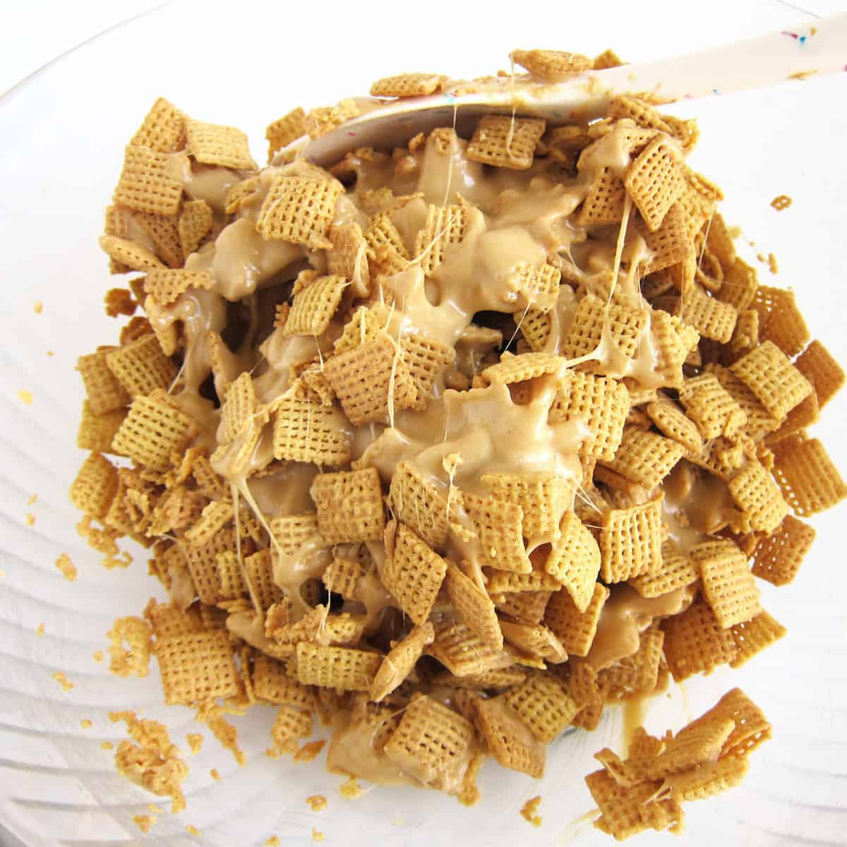 stirring peanut butter chex cereal with the peanut butter marshmallow mixture