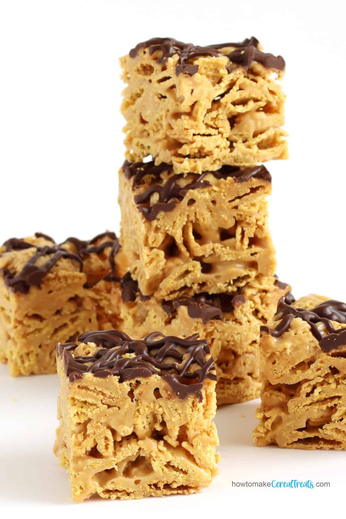 peanut butter cereal bars drizzled with chocolate are stacked on top of each other