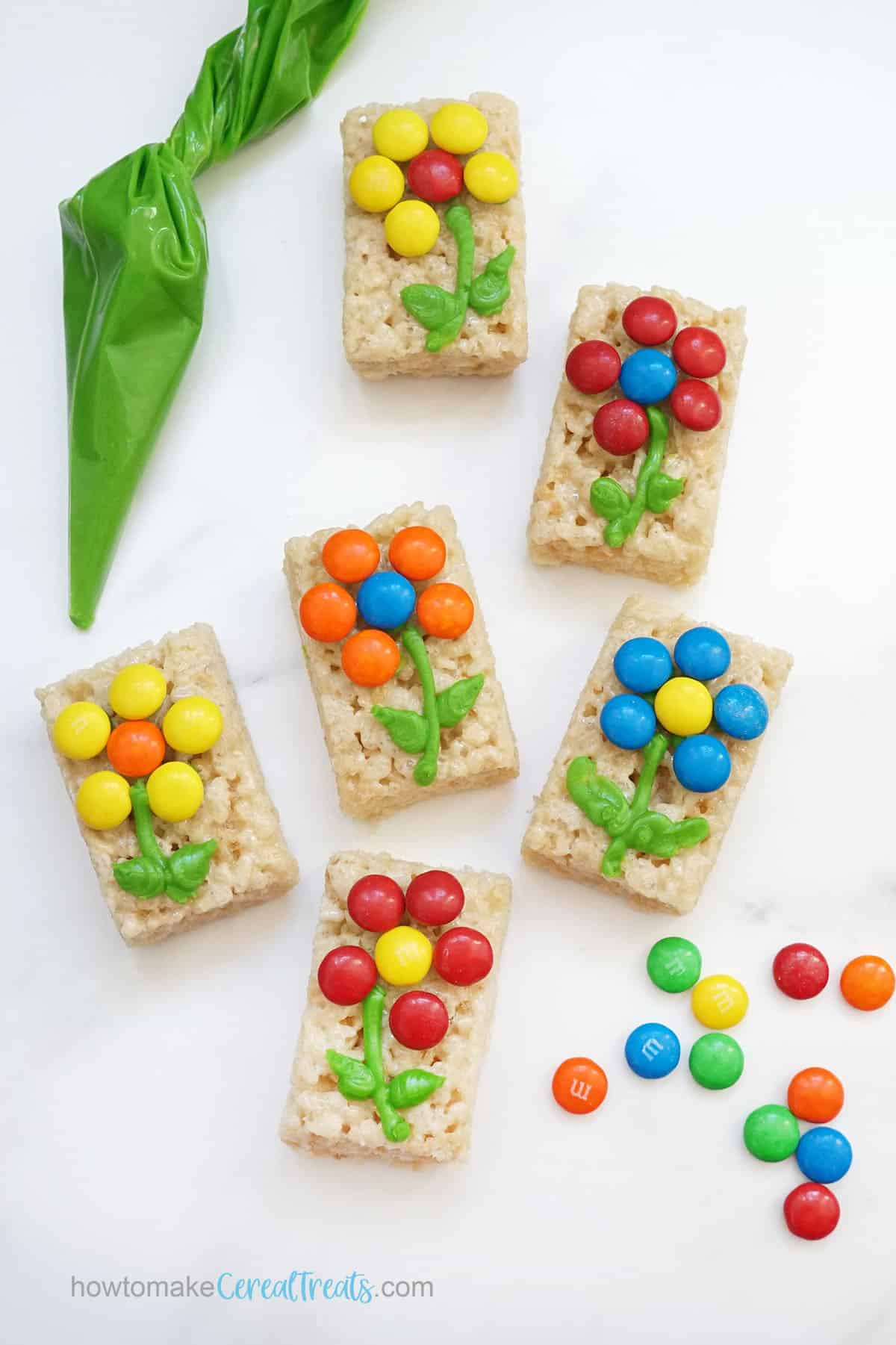 piping candy flowers on Rice Krispie Treats