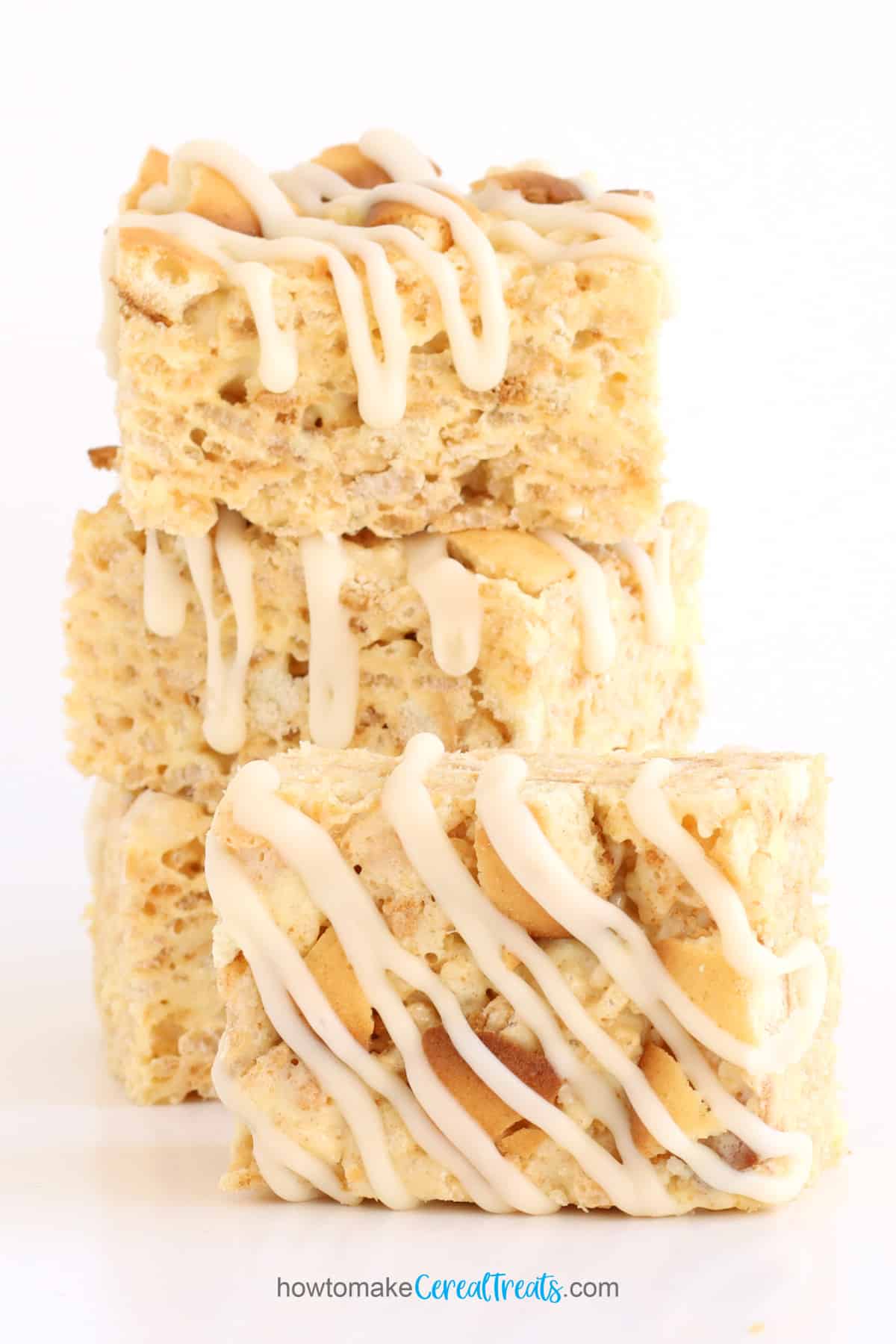 banana pudding rice krispie treats topped with vanilla wafer cookie pieces and vanilla glaze