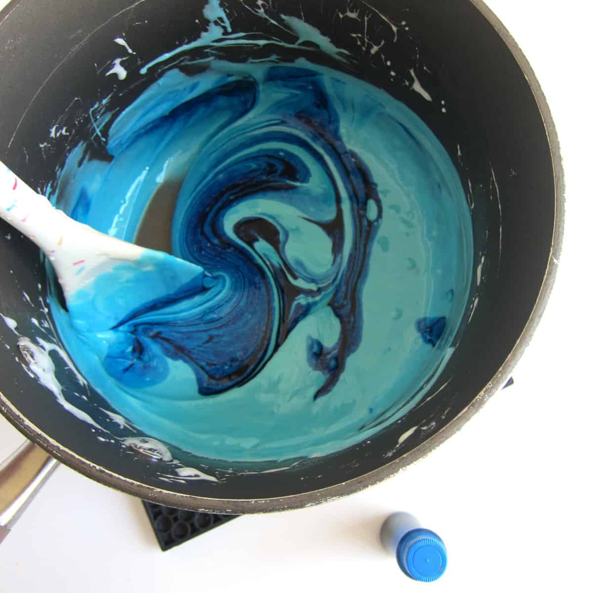 stirring blue food coloring into melted marshmallows