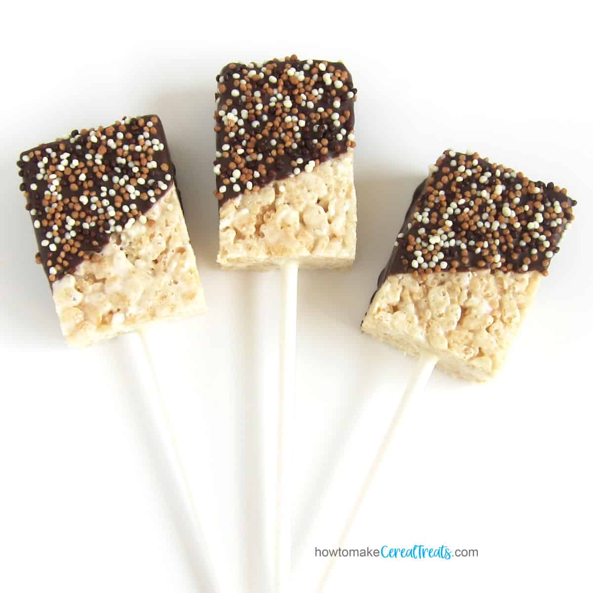 Chocolate-dipped Rice Krispie Treat pops on a stick topped with milk, dark, and white Crispearls.