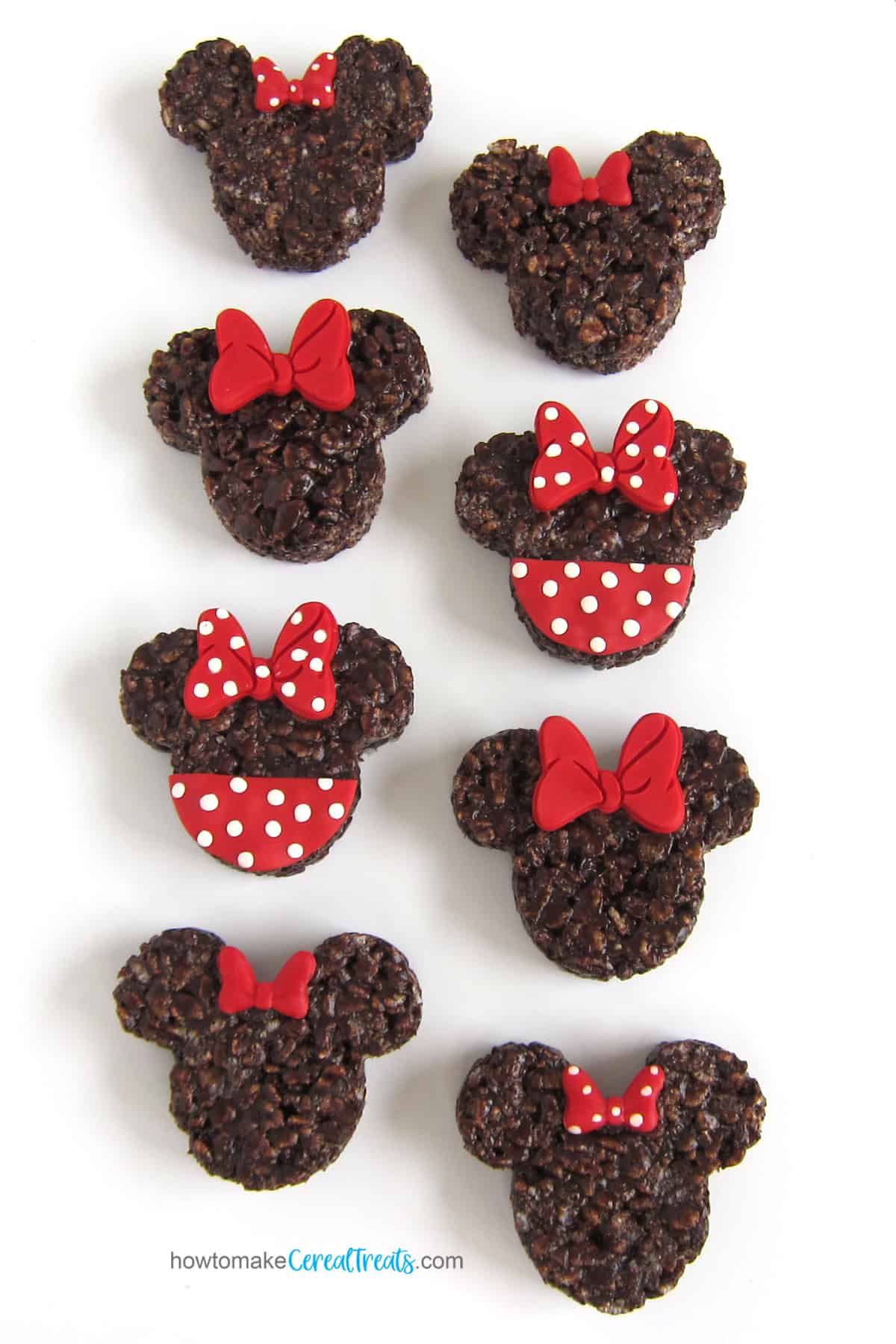 Minnie Mouse Rice Krispie Treats decorated with red and white modeling chocolate bows
