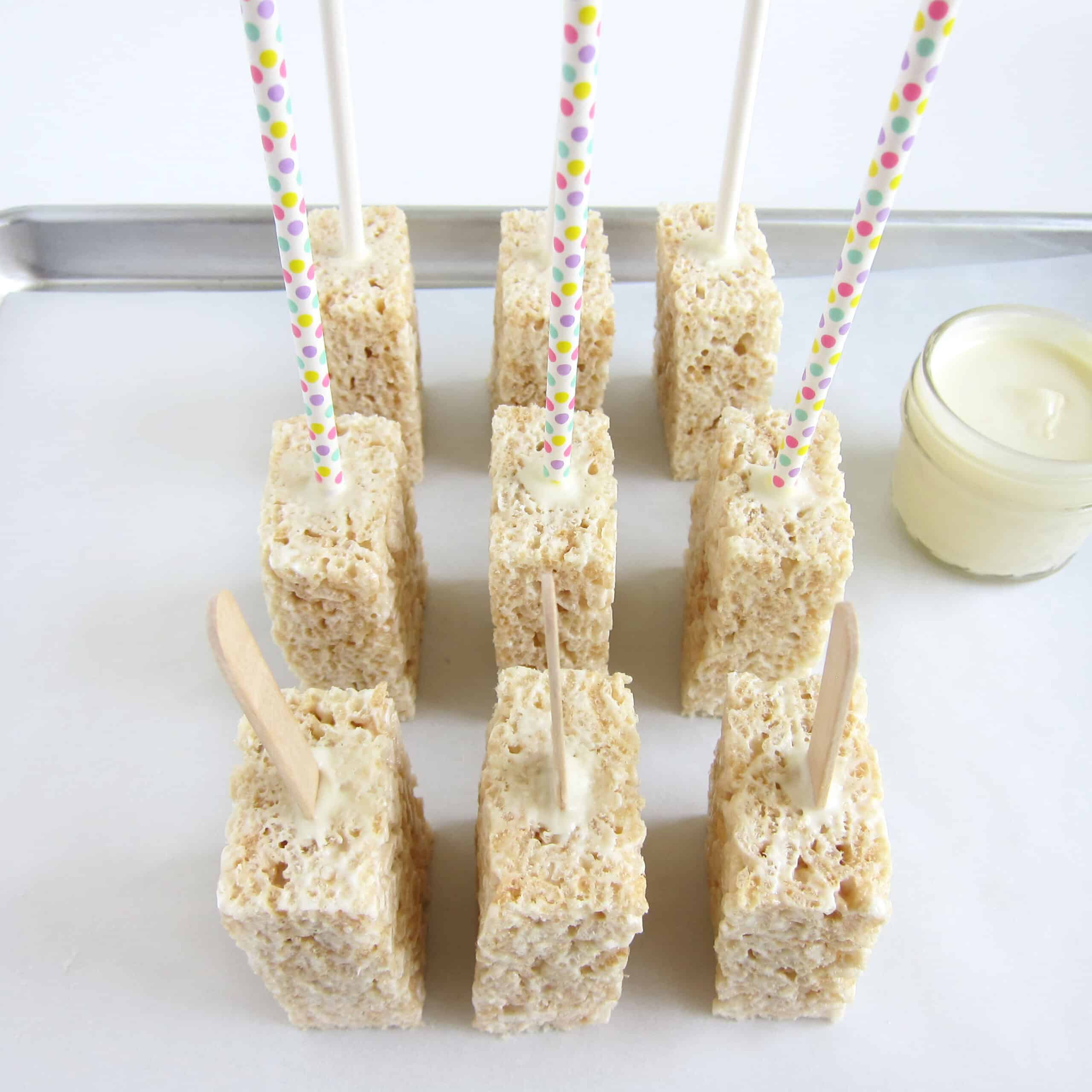 Rice Krispie treats with popsicle sticks, lolllipop sticks, and popsicle sticks secured with melted white chocolate.