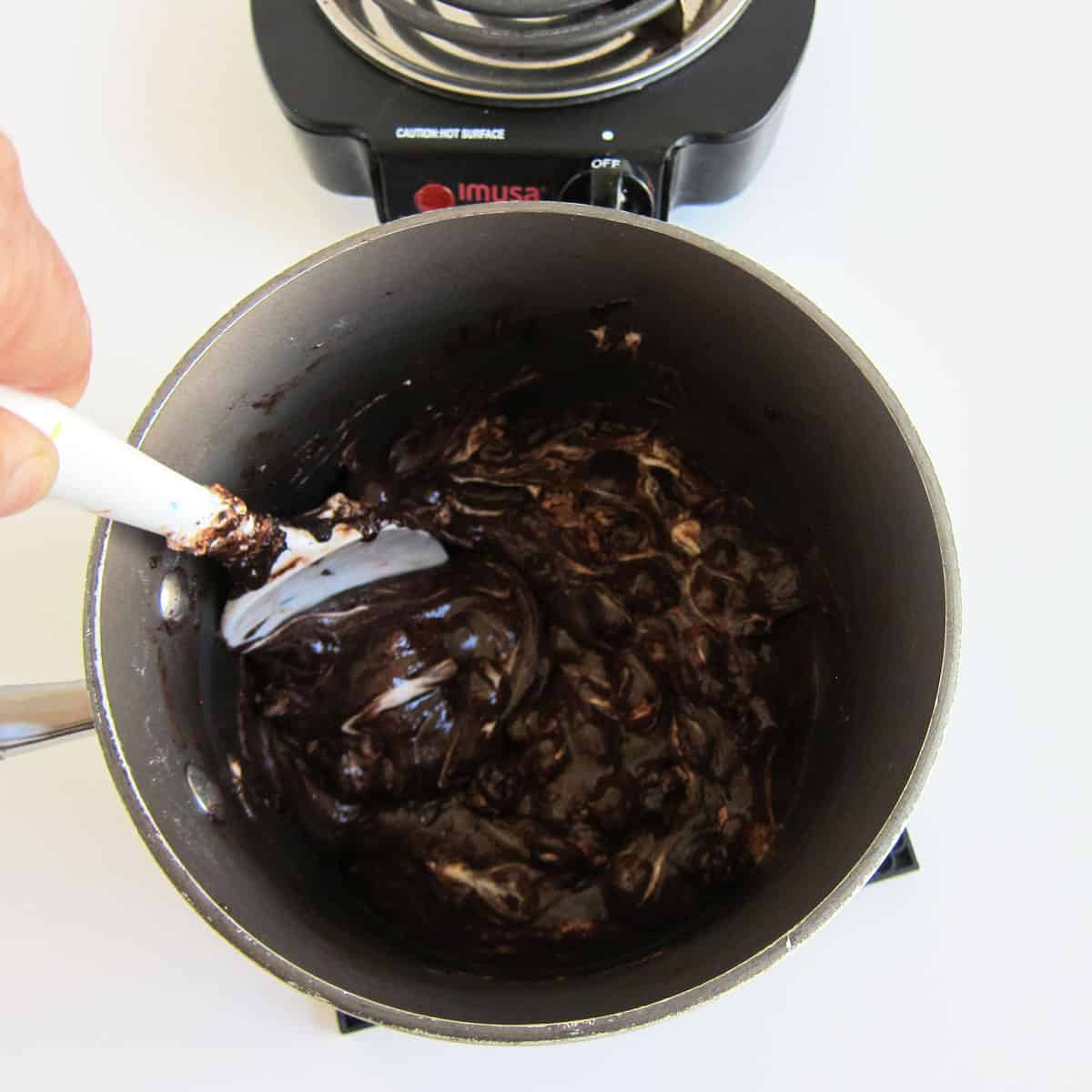 stirring chocolatey marshmallows in saucepan off heat