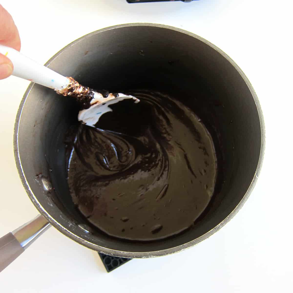 stirring melted butter, marshmallows, chocolate, and cocoa powder together until smooth