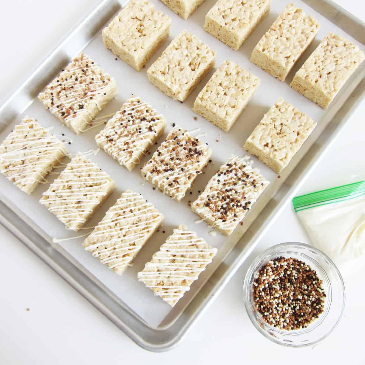 White chocolate crispy treats topped with a drizzle of white chocolate and dark, milk, and white Crispearls.
