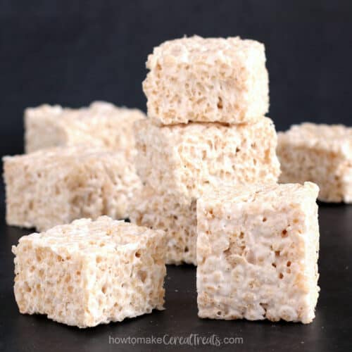 dairy free rice krispie treat squares arranged on a black table with a black background