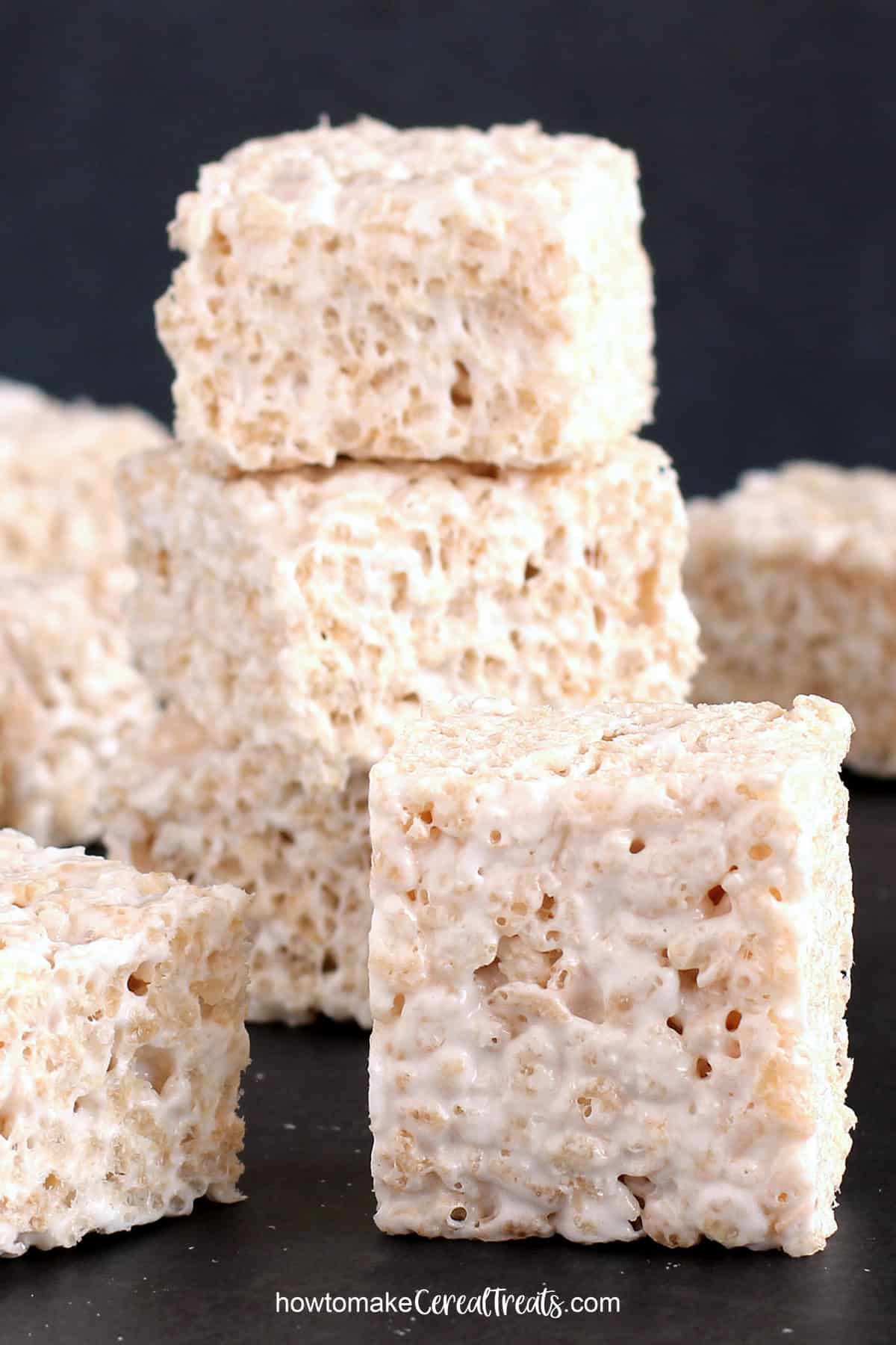 gooey dairy-free marshmallow Rice Krispie treats stacked on a black table