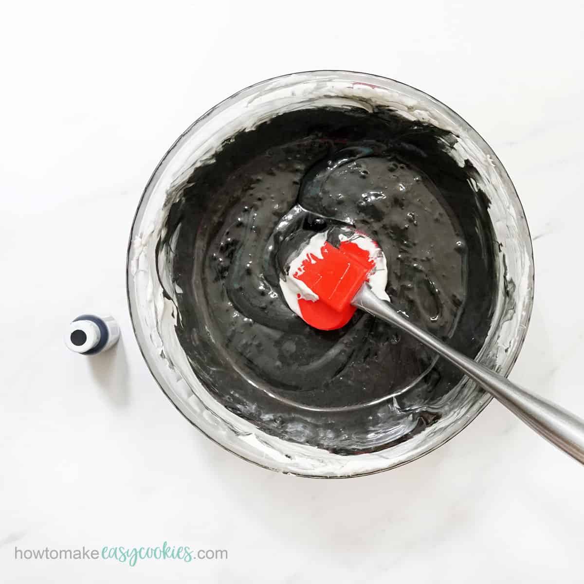 mixing black food coloring into melted marshmallows