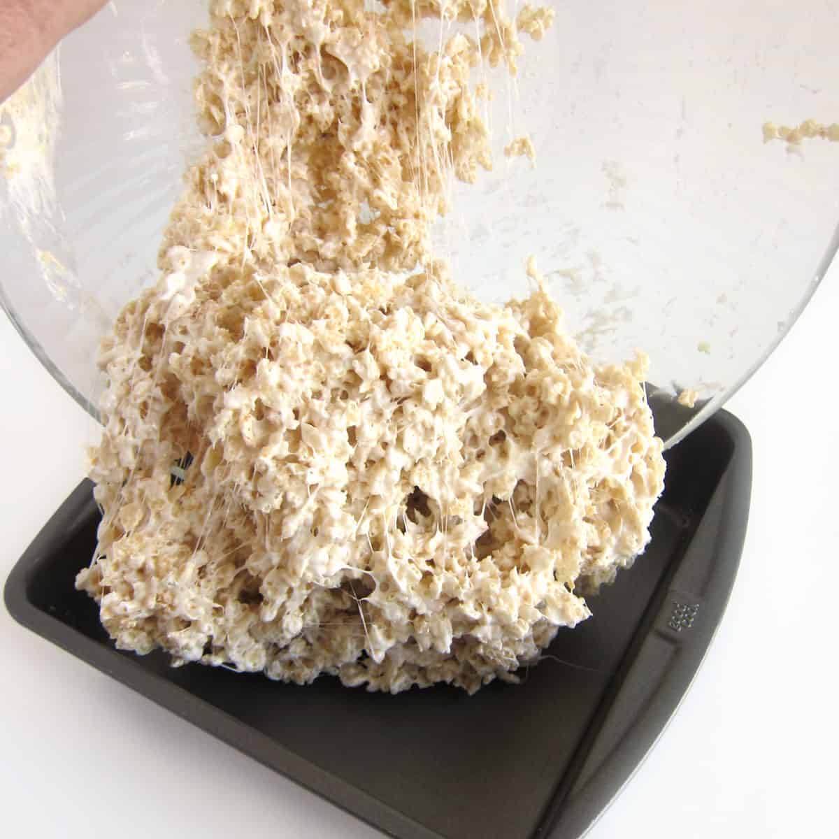 Pouring dairy-free Rice Krispie treats into pan. 