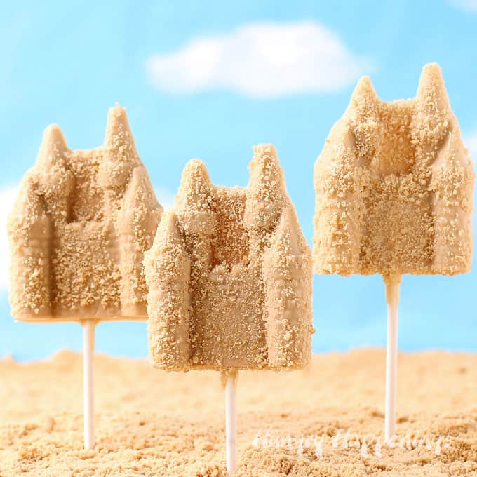 sand castle lollipops in cookie crumb sand with a blue sky backdrop