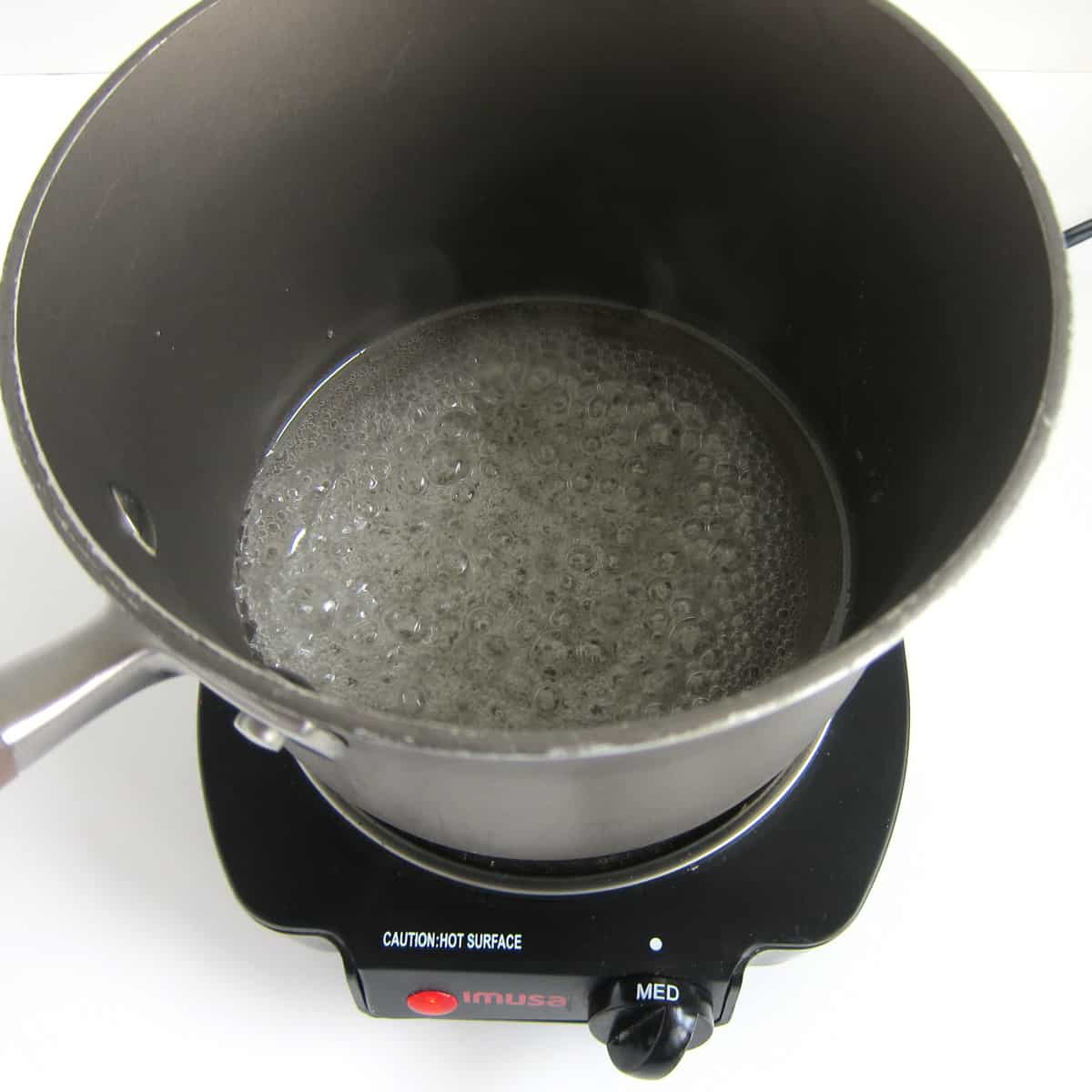 boiling light corn syrup in a saucepan.