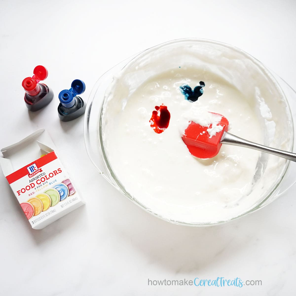 mixing liquid food coloring into marshmallow mixture for Rice Krispie Treats