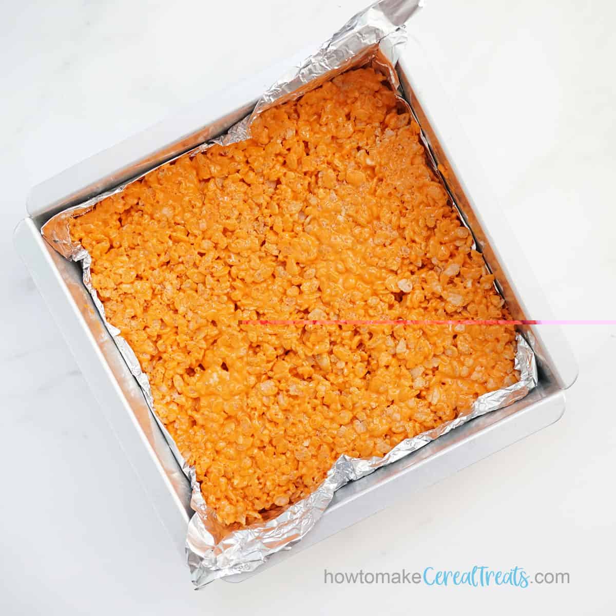 orange rice krispie Treats in square baking pan