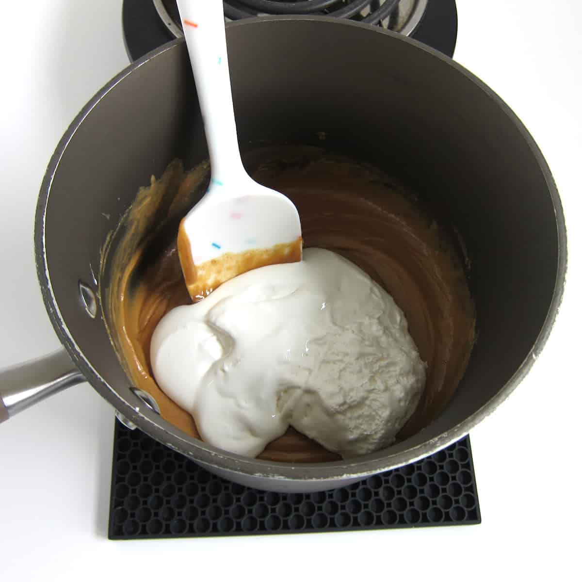 add marshmallow fluff to the melted peanut butter and corn syrup.