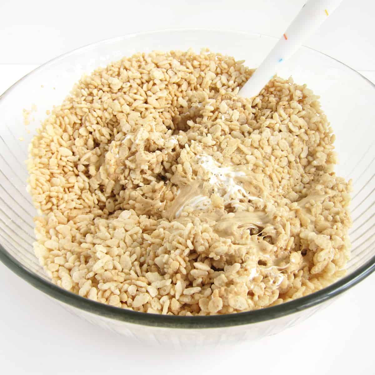 mixing Fluffernutter Rice Krispie Treats in a bowl.