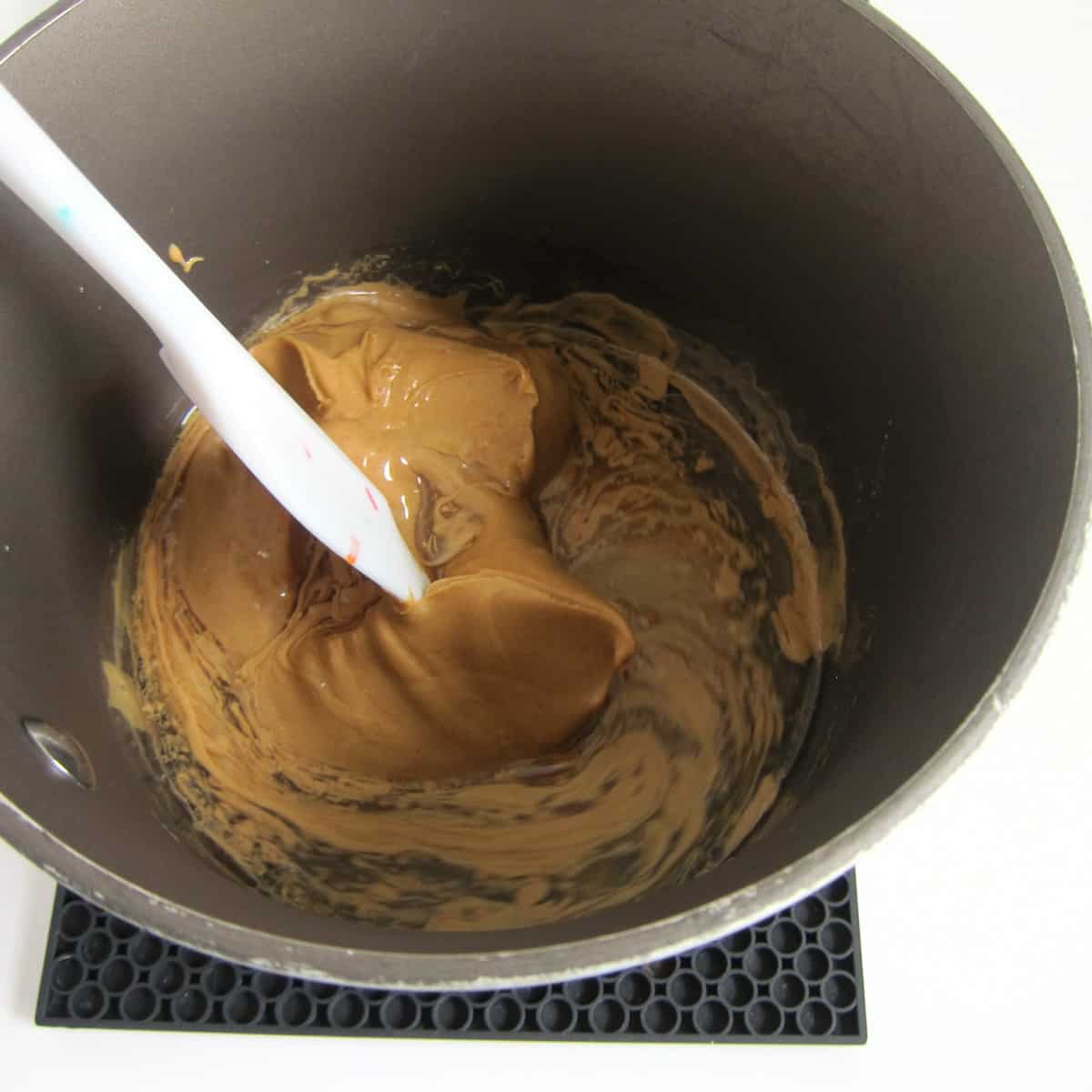 stirring creamy peanut butter into corn syrup.