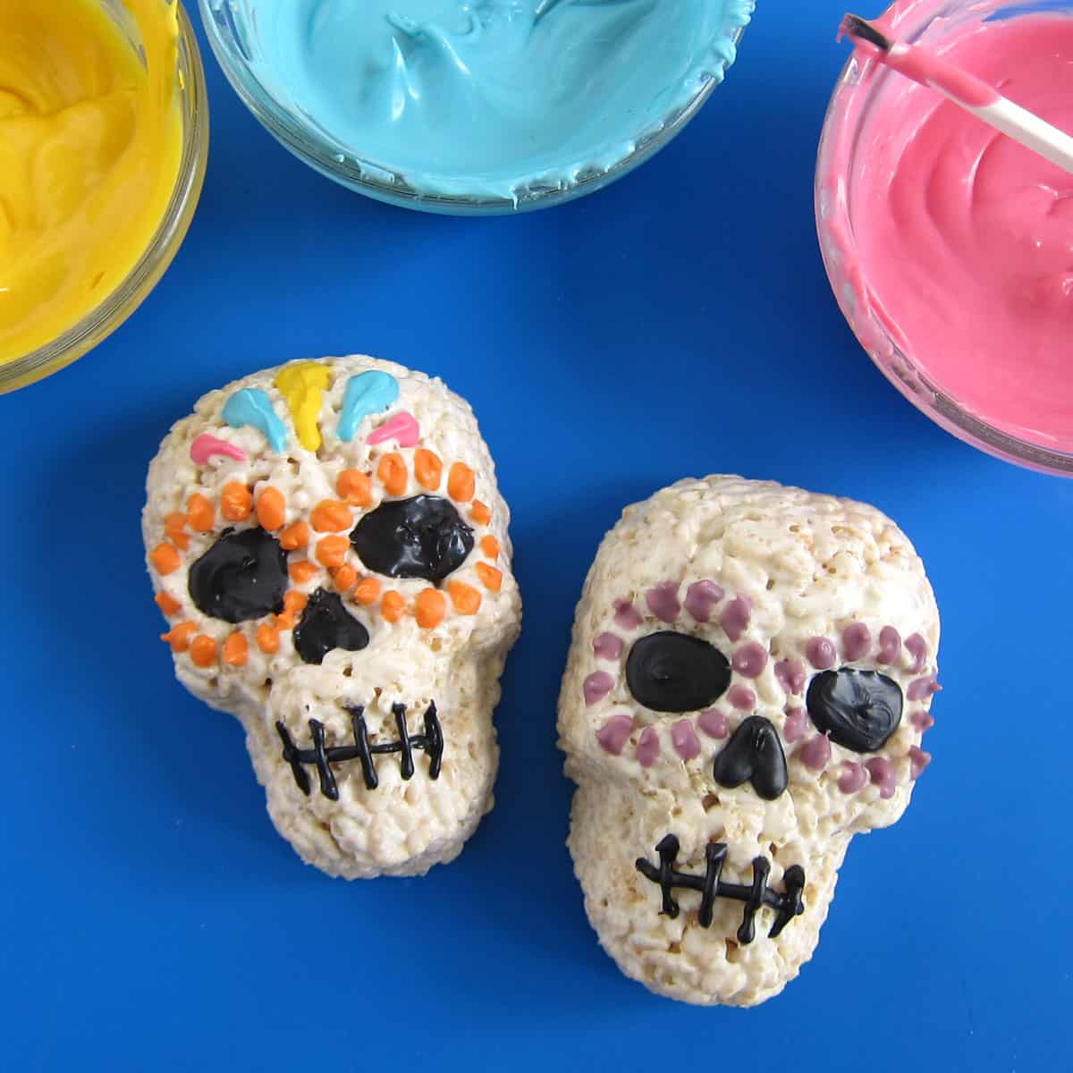 painting colorful teardrops onto a sugar skull Rice Krispie Treat.