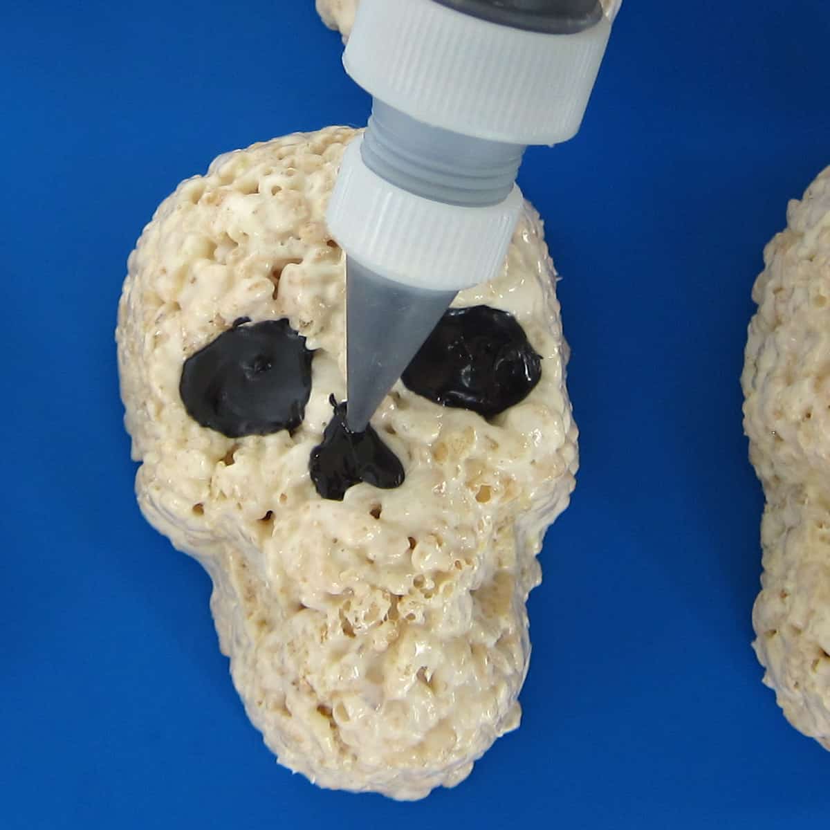 piping black candy melts into the nose cavity of the crispy treat skull.