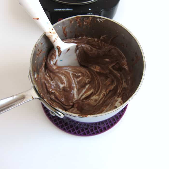 stirring melted butter, chocolate, hot cocoa, and marshmallows until melted.