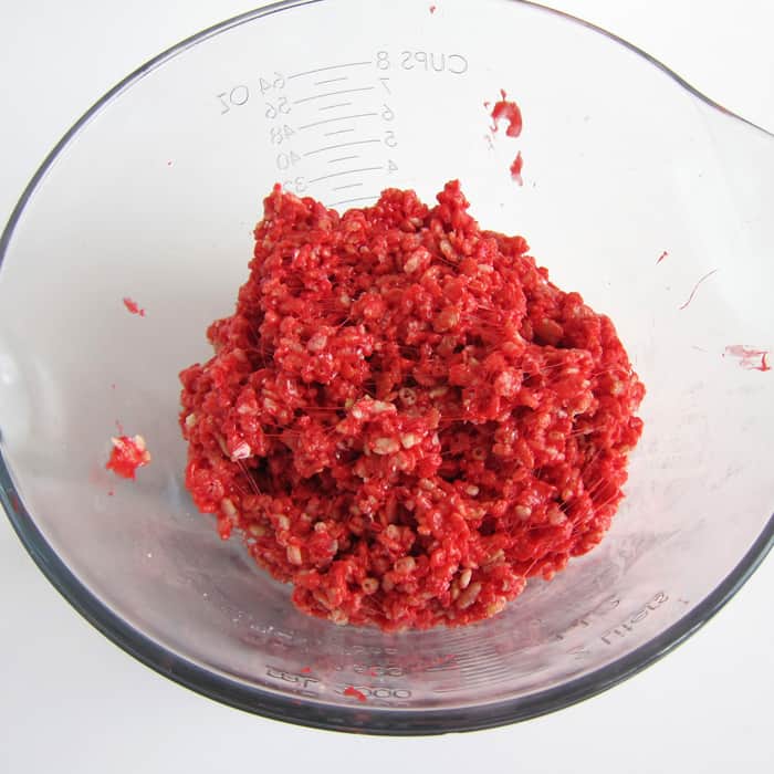 red peppermint rice krispie treat mixture blended together in the mixing bowl.